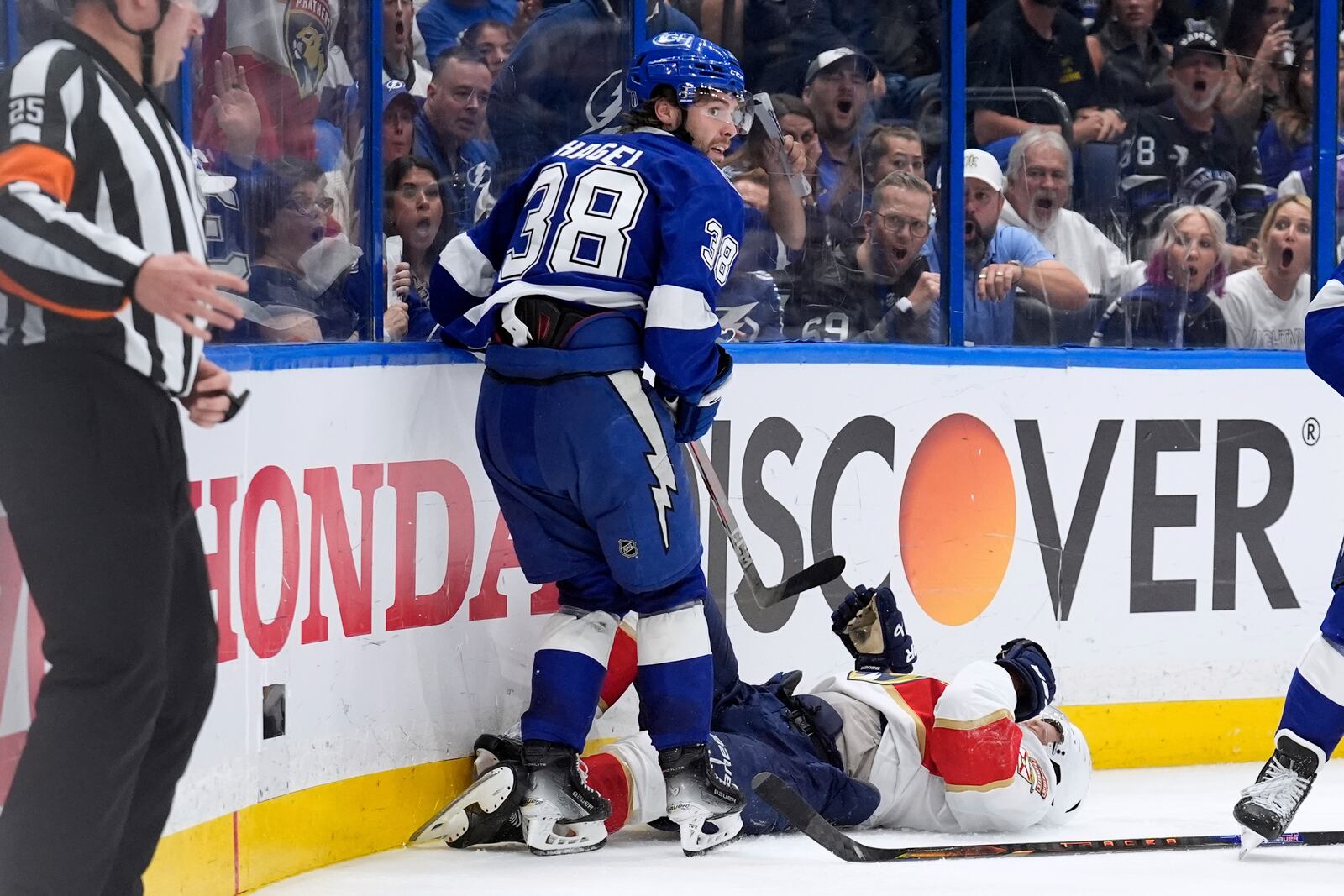 Tampa Bay Lightning left wing Brandon Hagel (38) takes down Florida Panthers center Aleksander Barkov during the third period in Game 2 of an NHL hockey Stanley Cup first-round playoff series, Thursday, April 24, 2025, in Tampa, Fla. (AP Photo/Chris O'Meara)