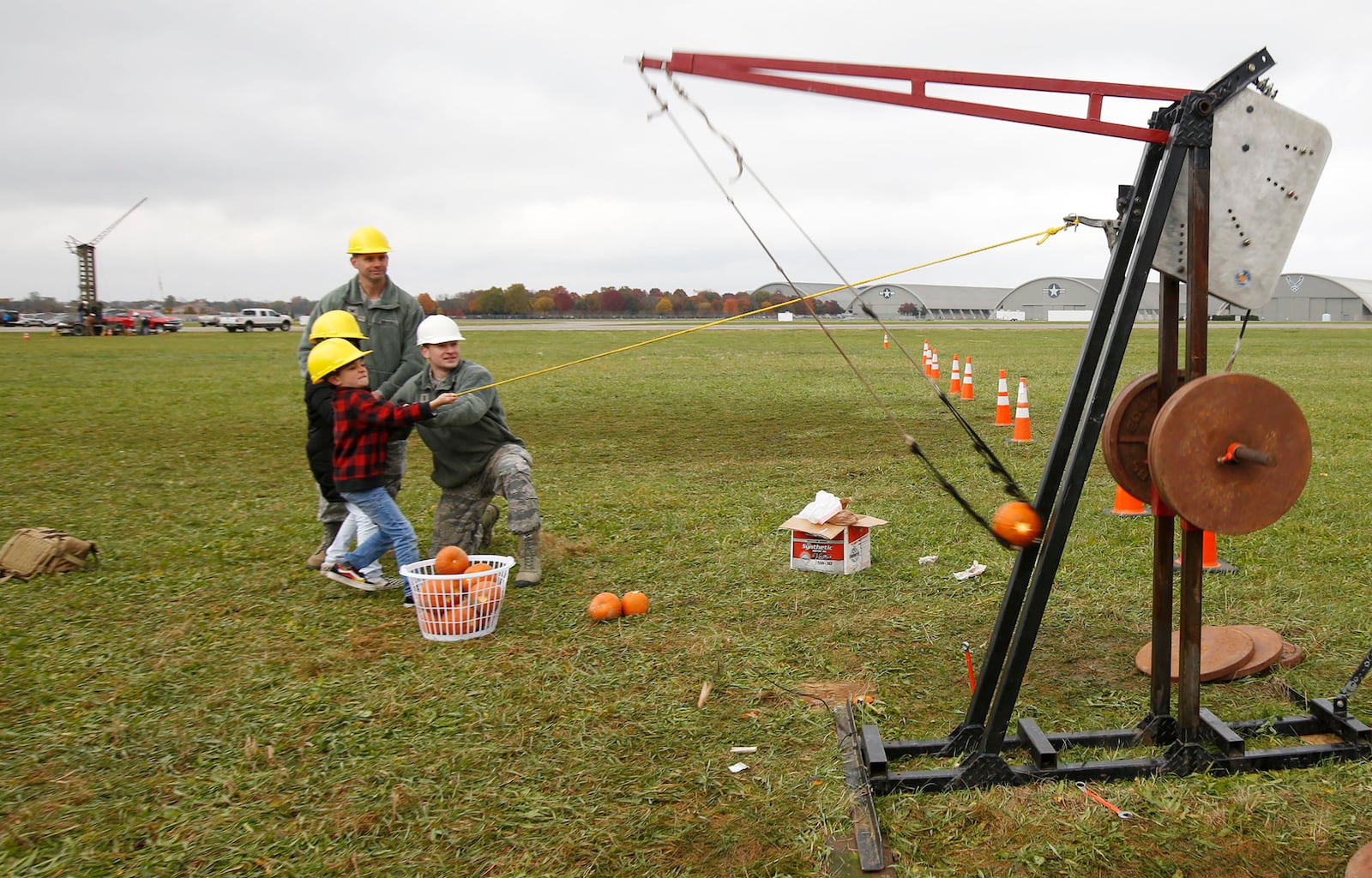 Col. Chris Snyder's children Mallory and Ethan pull the pin of a Class B pumpkin chucker at Wright-Patterson Air Force Base on Friday afternoon.  The 14th annual Pumpkin Chuck was sponsored by the Air Force Life Cycle Management Center Engineering Directorate's STEM outreach.  More than 40 participants worked a dozen chucking machines to launch pumpkins from two pounds to 10 pounds as far as 3,800 feet.   TY GREENLEES / STAFF