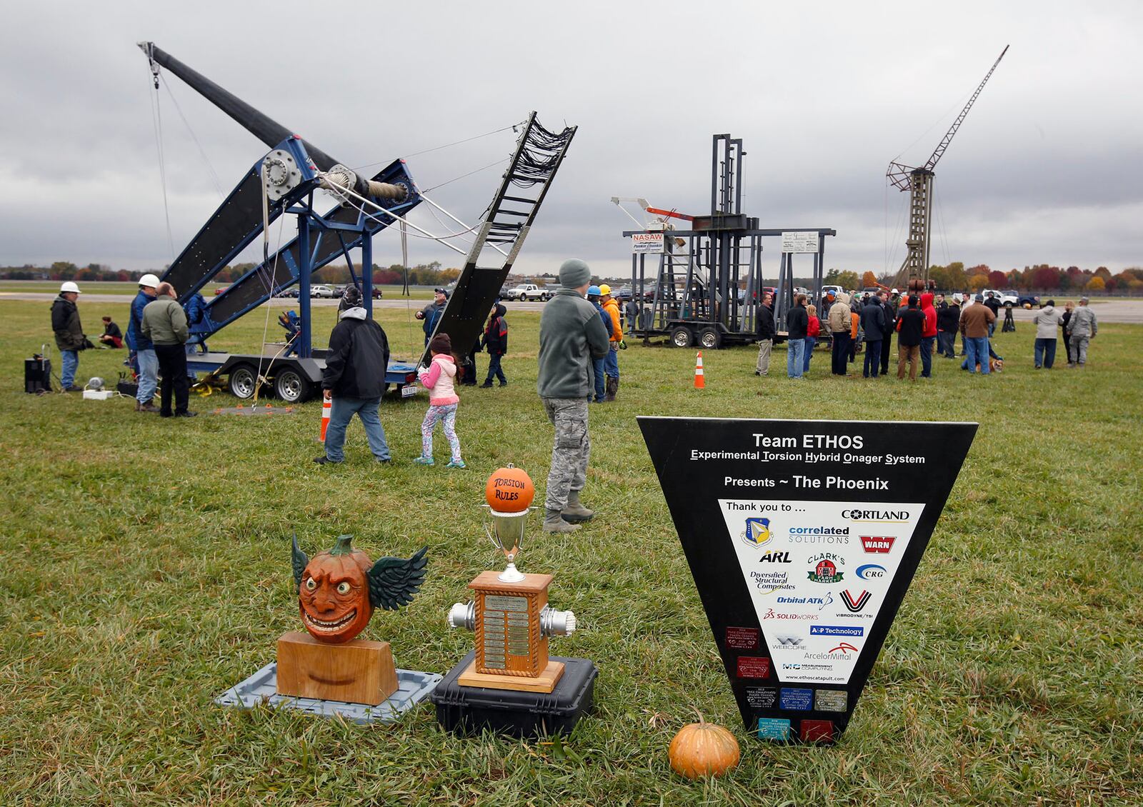 Trophies on display with Class A pumpkin chucking machines at Wright-Patterson Air Force Base on Friday afternoon.  The 14th annual Pumpkin Chuck was sponsored by the Air Force Life Cycle Management Center Engineering Directorate's STEM outreach.  More than 40 participants worked a dozen chucking machines to launch pumpkins from two pounds to 10 pounds as far as 3,800 feet.   TY GREENLEES / STAFF