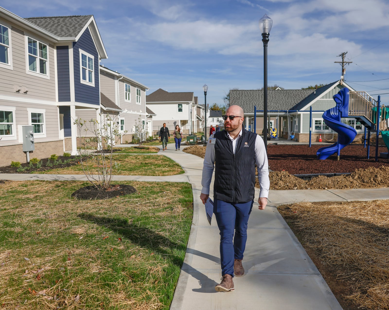 Benjamin Banning, philanthropy officer at Dayton Children's Hospital Foundation, prepares to walk into a home during a Dayton Children's Kinship Housing tour on Monday, October 27, 2025, in Dayton. JOSEPH COOKE/STAFF