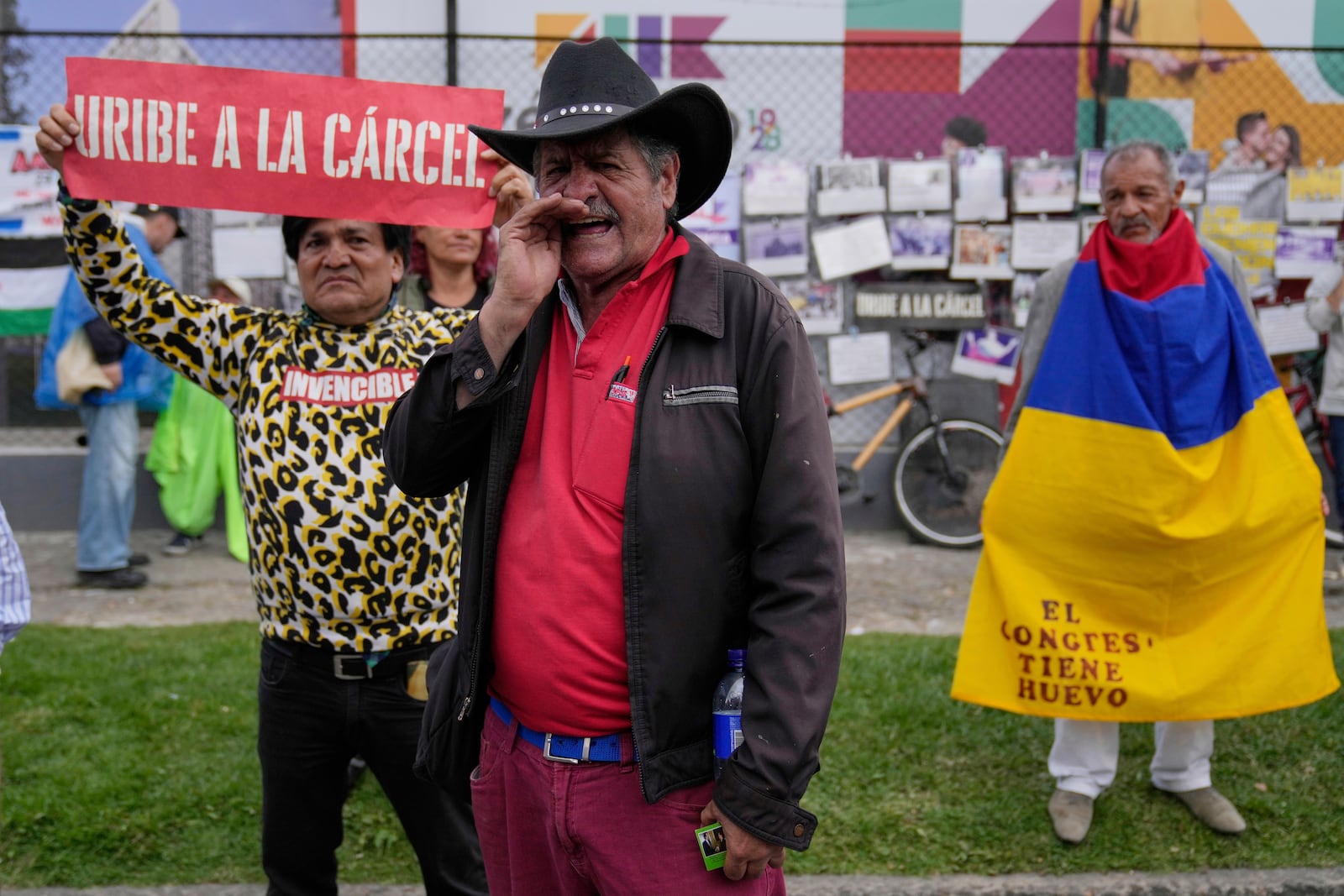 Opponents of former President Alvaro Uribe gather outside the court where a verdict is expected in his trial for witness tampering in Bogota, Colombia, Monday, July 28, 2025. (AP Photo/Fernando Vergara)