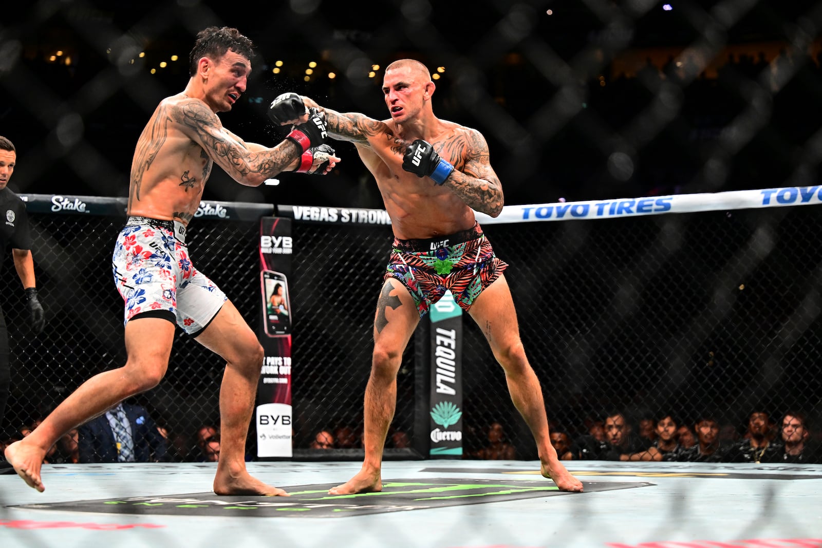Dustin Poirier, right, hits Max Holloway in a lightweight title fight at UFC 318 in New Orleans, La., Saturday, July 19, 2025. (AP Photo/Ella Hall)