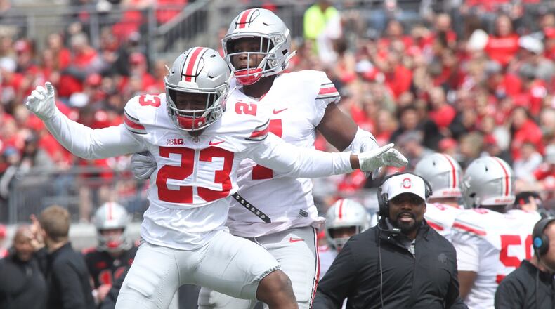 Ohio State’ Jahsen Wint (23) celebrates after intercepting a pass with Teradja Mitchell during the spring game on Saturday, April 13, 2019, at Ohio Stadium in Columbus. David Jablonski/Staff
