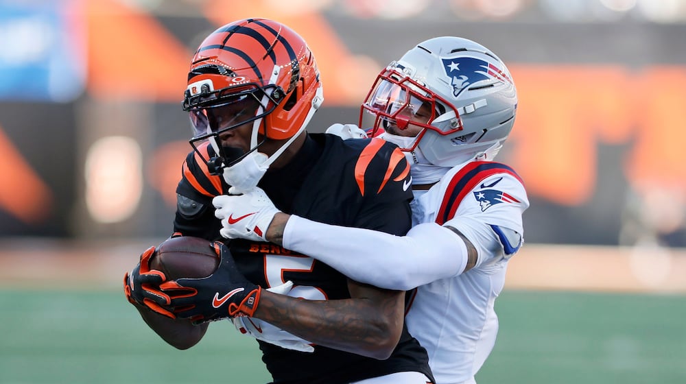 Cincinnati Bengals wide receiver Tee Higgins (5) is tackled by New England Patriots cornerback Carlton Davis III after catching a pass during the second half of an NFL football game, Sunday, Nov. 23, 2025, in Cincinnati. (AP Photo/Jay LaPrete)