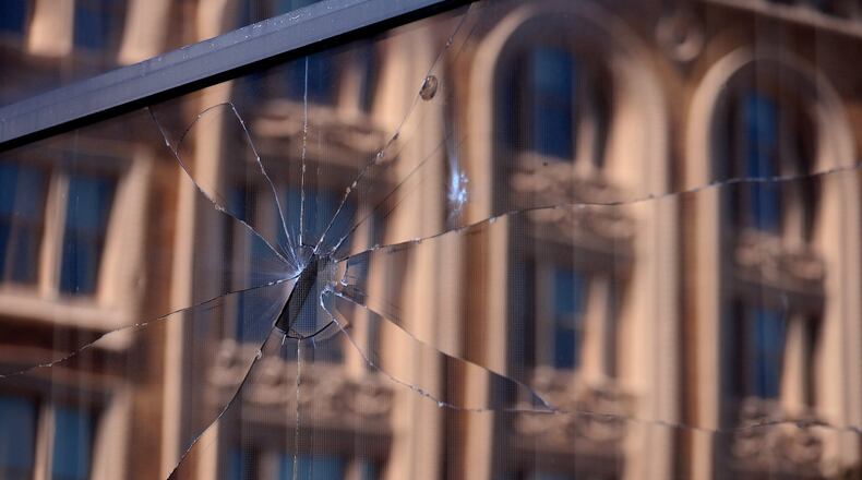A broken window in EF Hutton Tower in downtown Springfield Monday morning. BILL LACKEY/STAFF