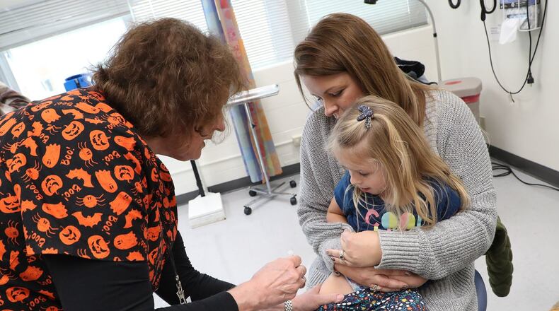 Jennie Rohrer, a registered nurse at the Clark County Combined Health District, gives Willow Brooks, 3, a flu shot as her mother, Tammy, holds her Wednesday. BILL LACKEY/STAFF