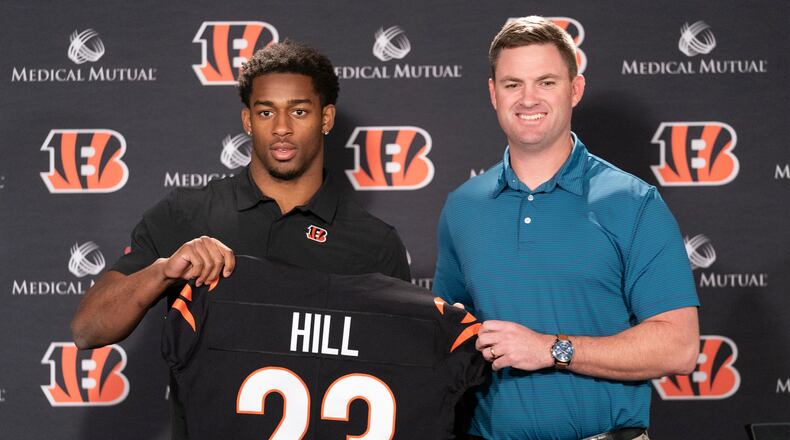Cincinnati Bengals head coach Zac Taylor, right, holds up a team jersey with Daxton Hill for a photo after introducing Hill as the NFL football team's first-round pick during a news conference Friday, April 29, 2022, in Cincinnati. (AP Photo/Jeff Dean)