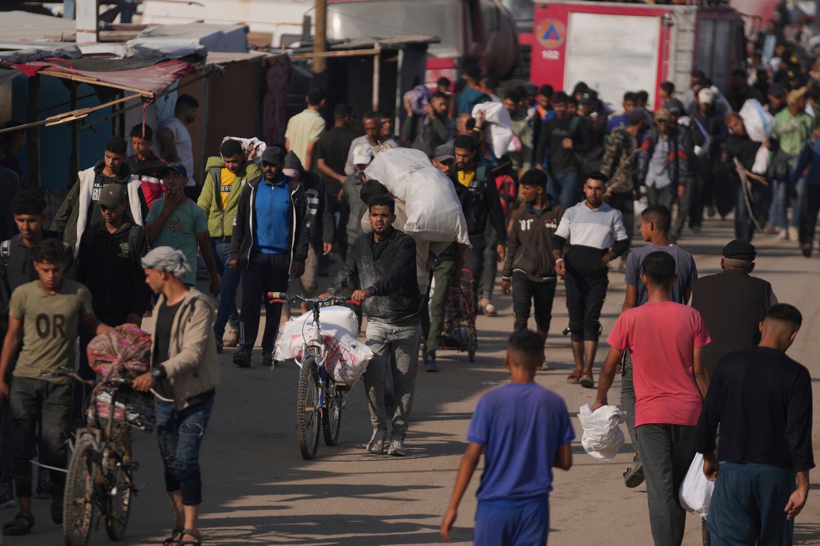 Palestinians carry bags containing food and humanitarian aid packages delivered by the Gaza Humanitarian Foundation, a U.S.-backed organization approved by Israel in Khan Younis, southern Gaza Strip, Sunday, June 1, 2025. (AP Photo/Abdel Kareem Hana)