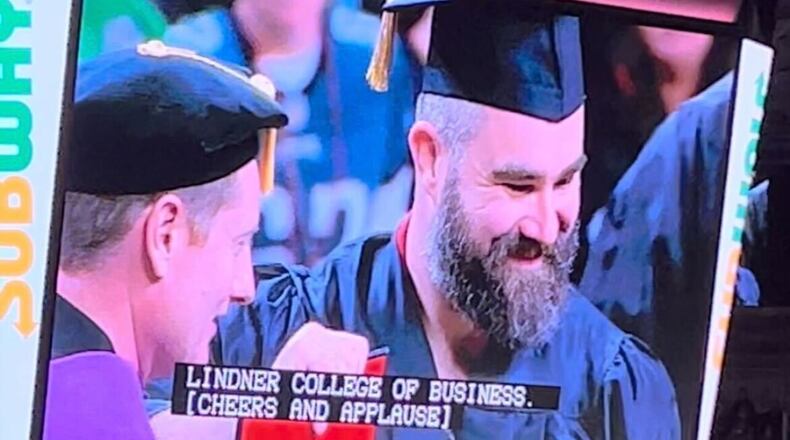 Jason Kelce, wearing shorts and a sleeveless vest under his cap and gown, didn't say anything while receiving his University of Cincinnati diploma — only smiling big and posing for pictures alongside school officials. WCPO/CONTRIBUTED