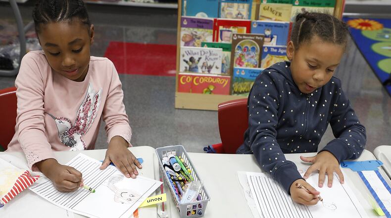 Justyce Bush, left, and Chasa’nae Brigham color pictures of the pets they have at home Friday during class at Perrin Woods Elementary School. Bill Lackey/Staff
