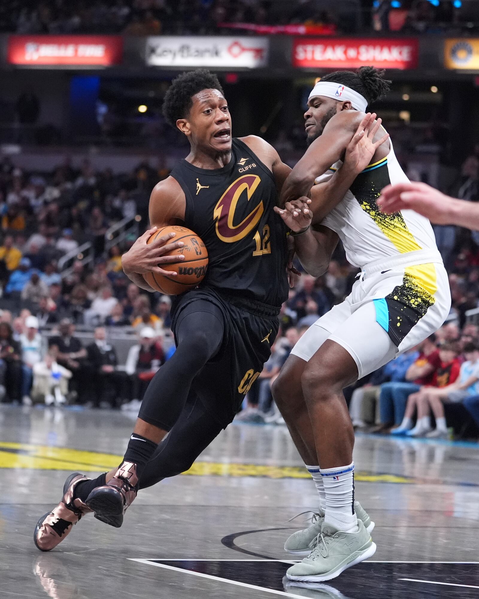 Cleveland Cavaliers forward De'Andre Hunter (12) drives on Indiana Pacers forward Jarace Walker (5) during the first half of an NBA basketball game in Indianapolis, Thursday, April 10, 2025. (AP Photo/Michael Conroy)
