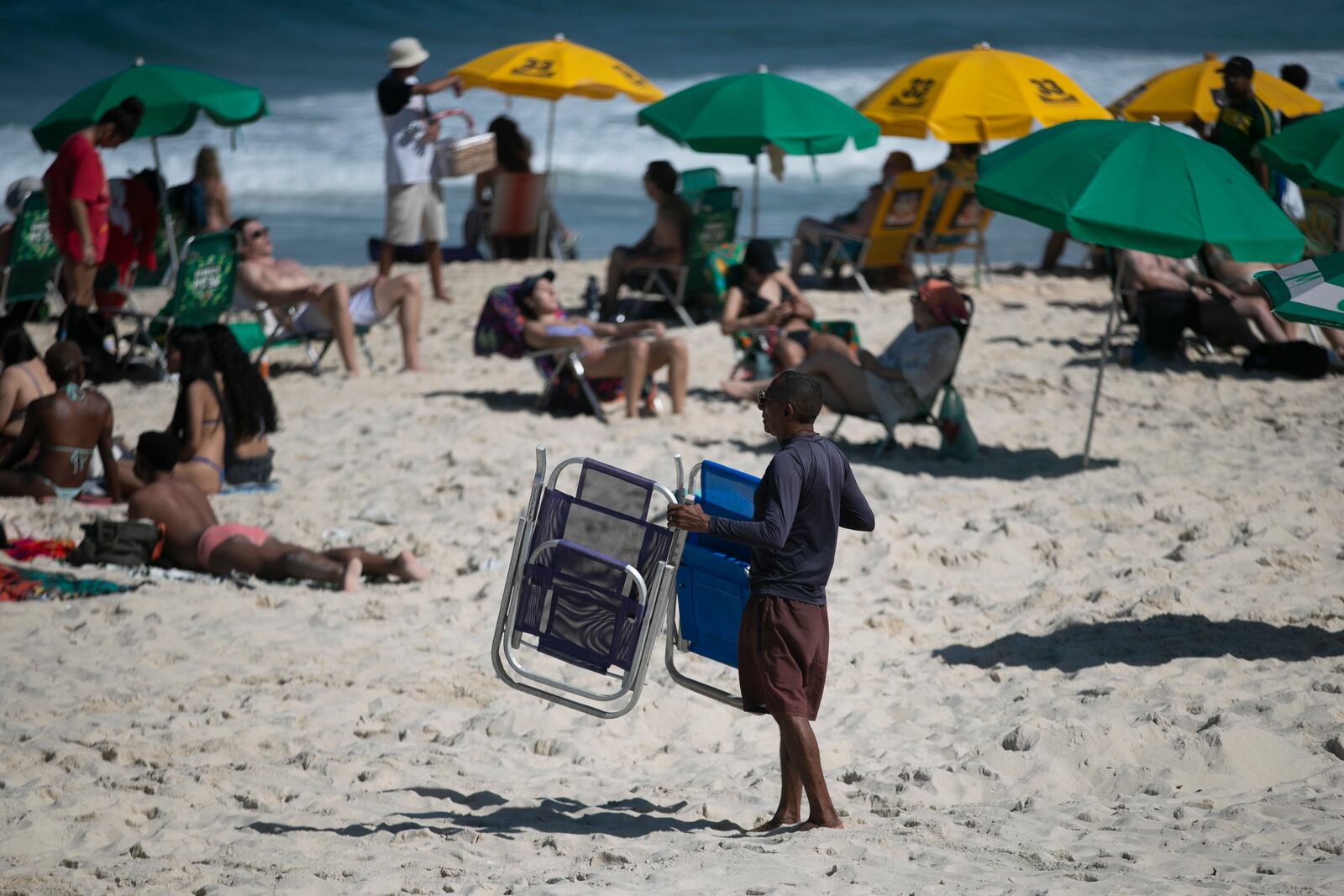 A man shows people chairs for rent on Ipanema Beach in Rio de Janeiro, Sunday, May 25, 2025. (AP Photo/Bruna Prado)
