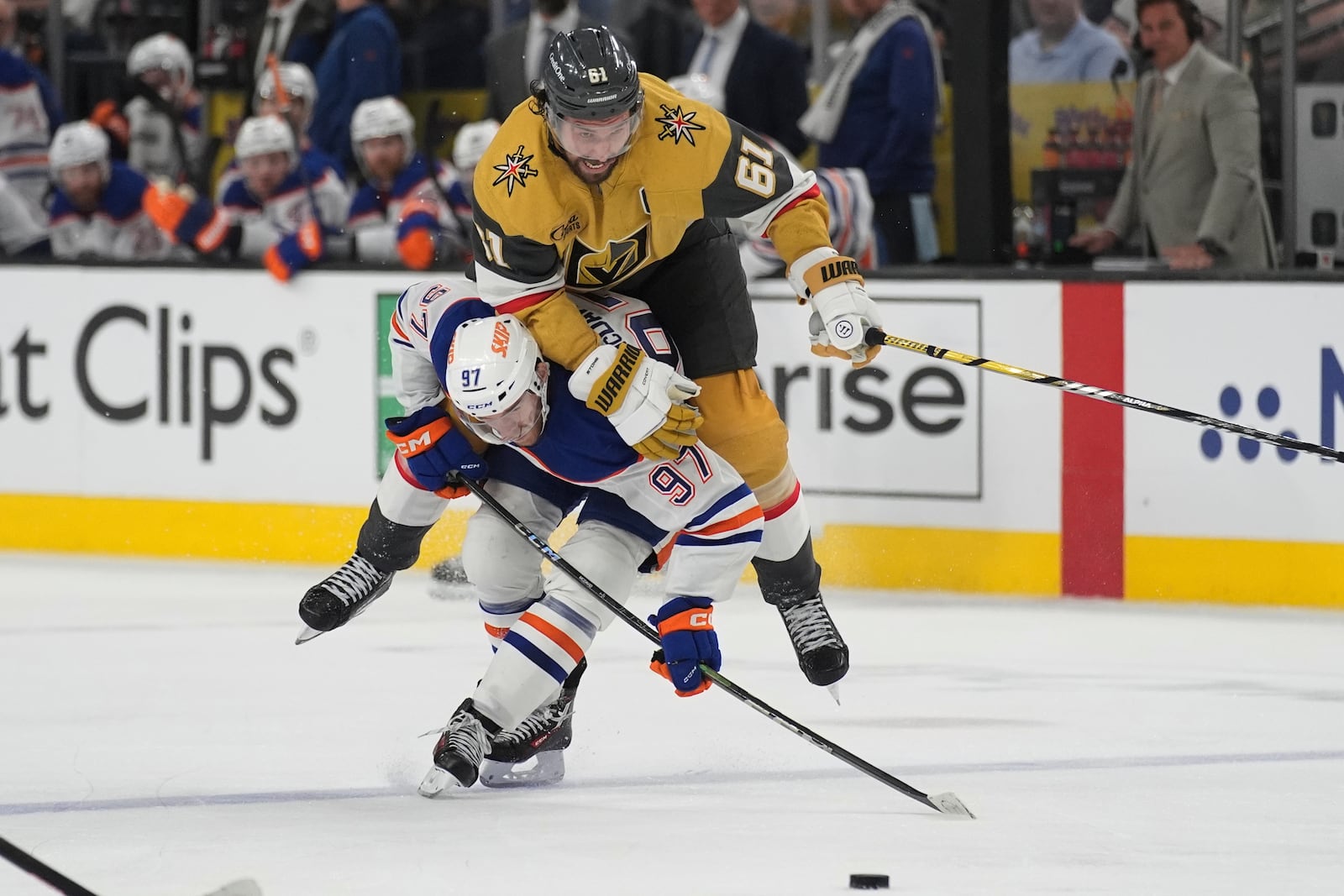 Vegas Golden Knights right wing Mark Stone (61) falls over Edmonton Oilers center Connor McDavid (97) during overtime of Game 2 of a second-round NHL hockey playoff series Thursday, May 8, 2025, in Las Vegas. (AP Photo/John Locher)