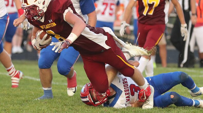 Northeastern’s Frederick Michael Burns is tripped up by Northwestern’s Gavin Thomas after catching a pass during Friday’s game. BILL LACKEY/STAFF