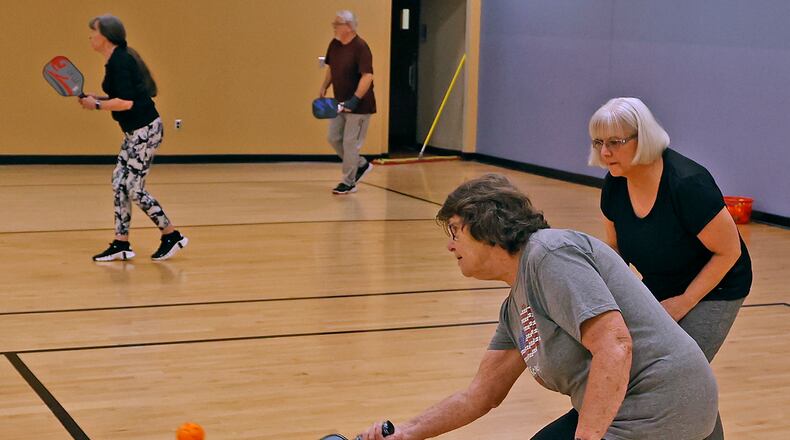 Helen Webb returns the ball as her partner, Ica Vega, stands by during their pickleball match at United Senior Services in Springfield on Wednesday, April 19, 2023. BILL LACKEY/STAFF