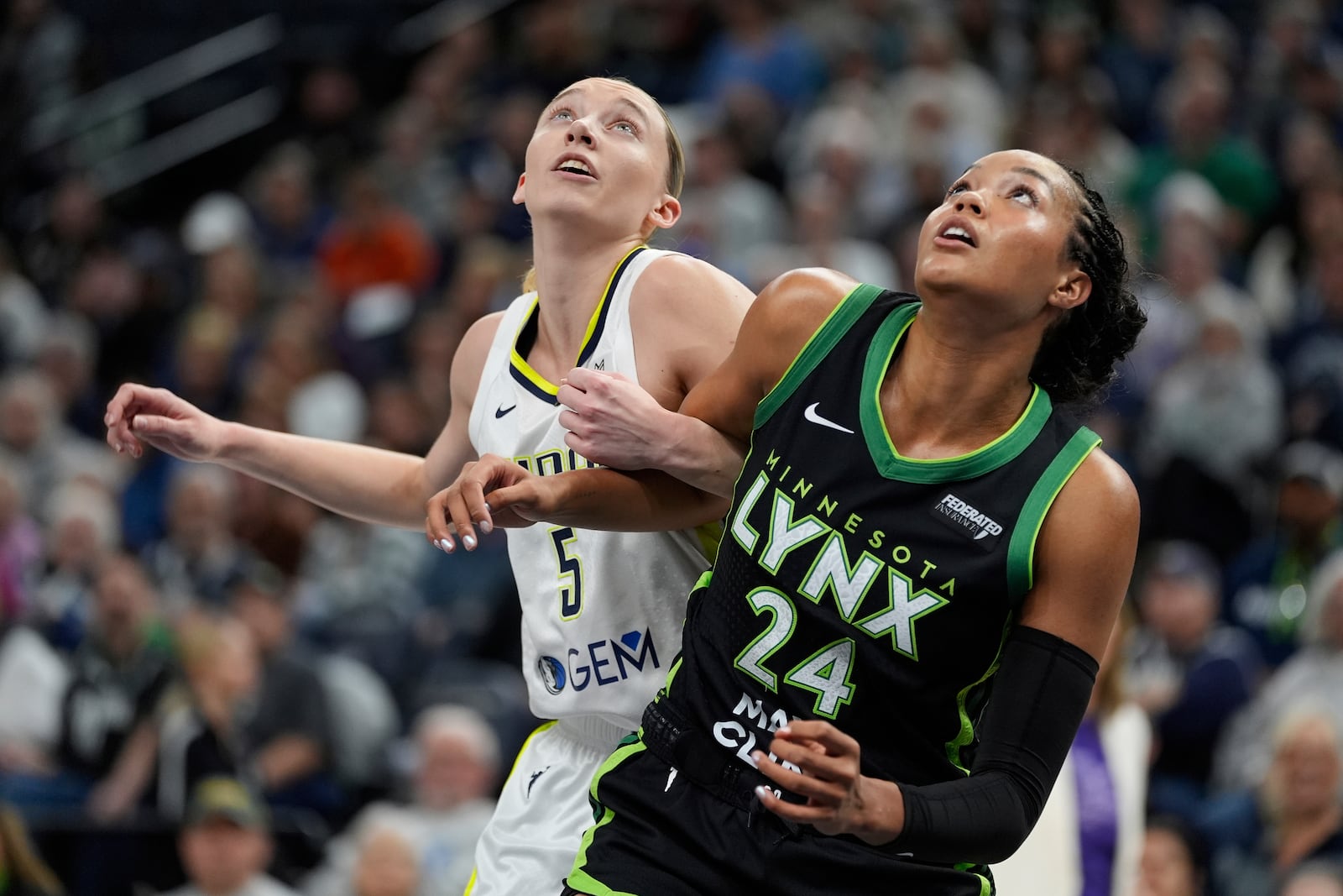Dallas Wings guard Paige Bueckers (5) and Minnesota Lynx forward Napheesa Collier (24) watch for a rebound during the first half of a WNBA basketball game Wednesday, May 21, 2025, in Minneapolis. (AP Photo/Abbie Parr)