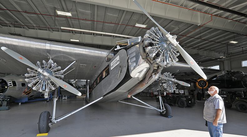 Ernie Holbrook looks over the 1928 Ford Tri-Motor airplane Thursday in the museum hanger at Grimes Field in Urbana. The historic airplane, the first airliner to be mass produced, will be based at Grimes Field this weekend and taking people for rides between 9am and 5pm through Sunday. BILL LACKEY/STAFF