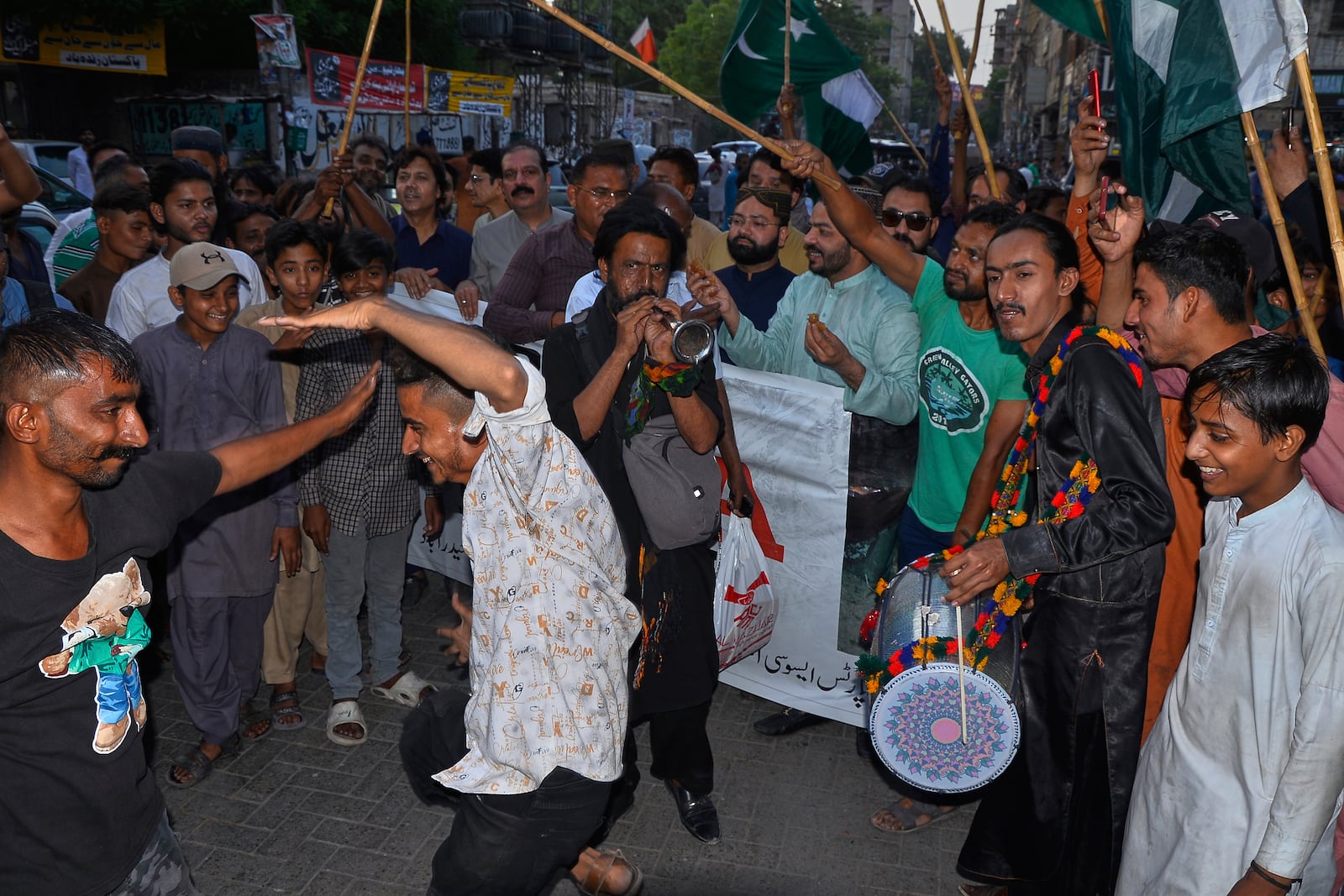 People dance on traditional drum beat as they celebrate following India and Pakistan reaching a ceasefire deal, during a demonstration, in Hyderabad, Pakistan, Saturday, May 10, 2025. (AP Photo/Pervez Masih)