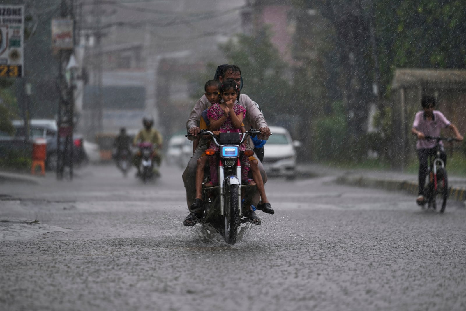 FILE - A motorcyclist with his family drive on a street during heavy rainfall in Rawalpindi, Pakistan, June 27, 2025. (AP Photo/Anjum Naveed, File)