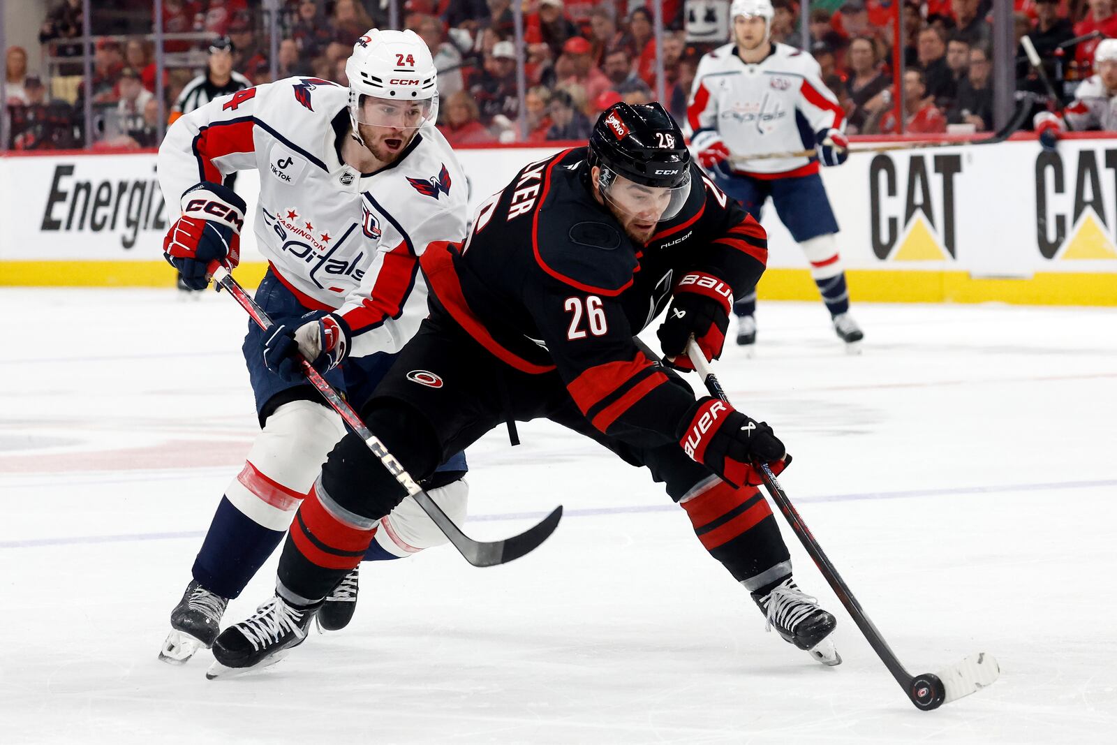 Carolina Hurricanes' Sean Walker (26) controls the puck in front of Washington Capitals' Connor McMichael (24) during the first period of Game 4 of a second-round NHL hockey playoff series in Raleigh, N.C., Monday, May 12, 2025. (AP Photo/Karl DeBlaker)
