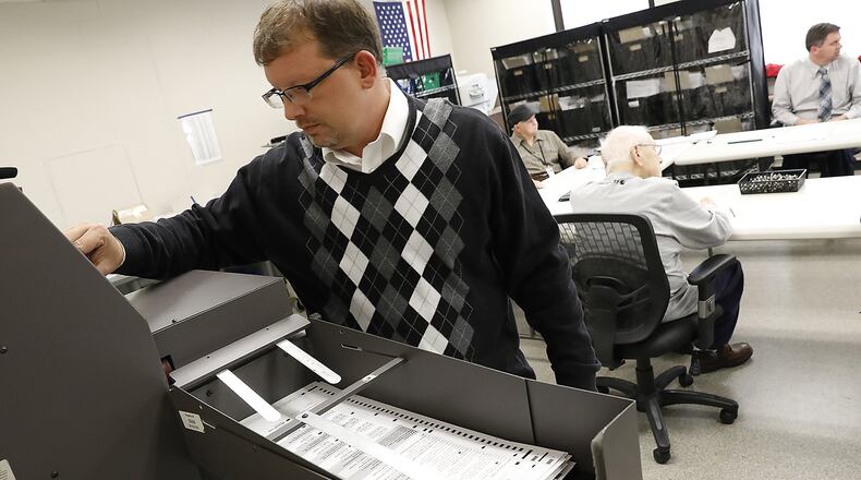 Jason Baker, director of the Clark County Board of Elections, runs the remaining ballots through a machine to count the votes for Springfield’s ballot issue last month. The Board of Elections and over departments have trimmed about three percent from its budget next year as the county will lose about $1 million in sales tax revenue next year and 3 million in 2018. Bill Lackey/Staff