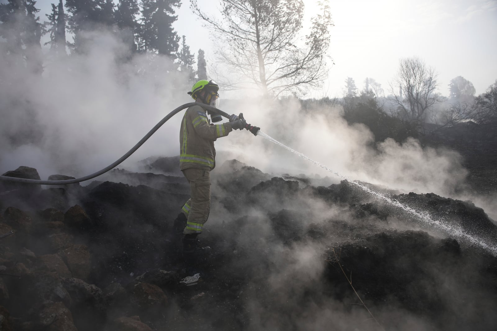 An Israeli firefighter battles a wildfire near Latrun, Israel, outside of Jerusalem, Thursday, May 1, 2025. (AP Photo/Ohad Zwigenberg)