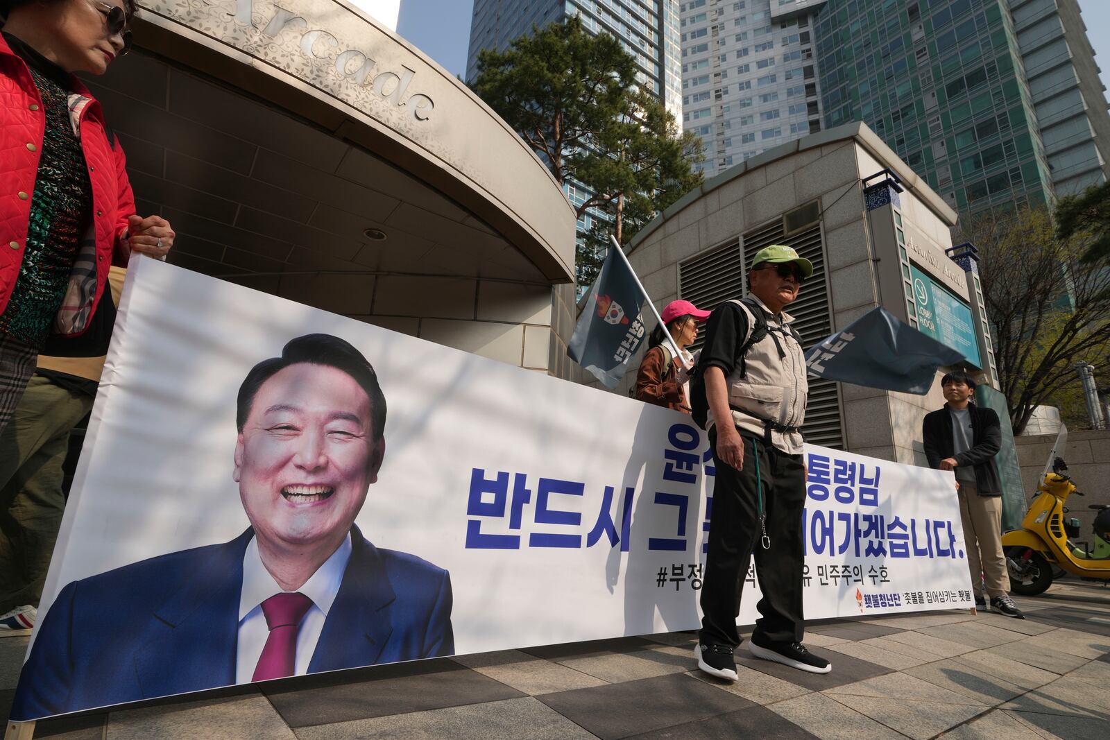 Supporters of recently removed South Korean President Yoon Suk Yeol hold a banner with a picture of Yoon near his private residence in Seoul, South Korea, Friday, April 11, 2025. The part of letters read "President Yoon Suk Yeol." (AP Photo/Lee Jin-man)