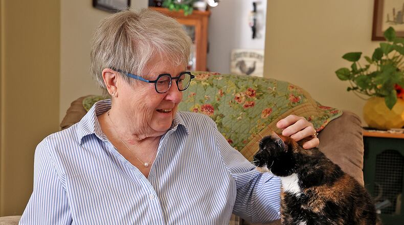 Judy Melvin, who is recovering from a heart attack, puts her cat Tuesday. BILL LACKEY/STAFF