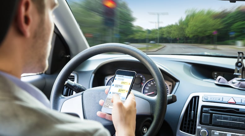 While it's illegal to use a phone while driving in Ohio, many are still looking at it at stoplights and while waiting on trains. ISTOCK