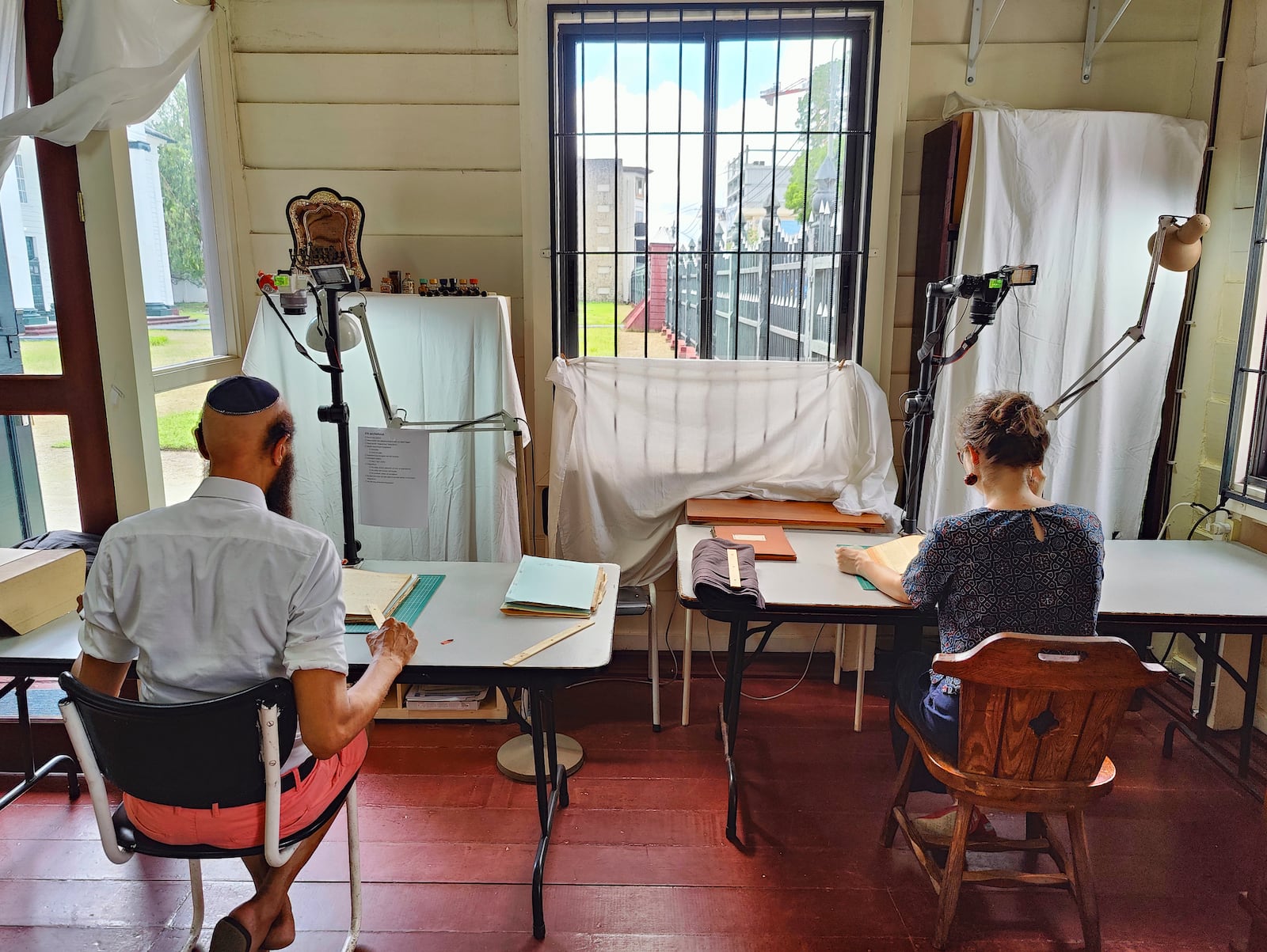 Ronnay Reeder, left, and Rosa de Jong scan images in Paramaribo, Suriname, Friday, May 2, 2025. (AP Photo/Oscar Keur)