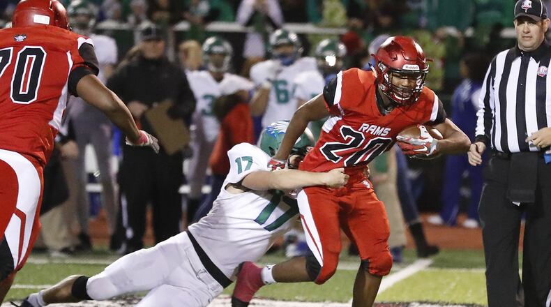 Trotwood’s Devontay Latimer tries to break a tackle by C.J.’s Anthony Burneka as he carries the ball. Bill Lackey/Staff