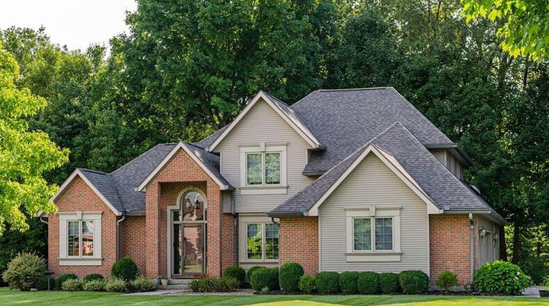 The front of home has a two-story covered portico, a front door with double side lights and lead glass windows above and a three-car attached, side-entry garage with openers. CONTRIBUTED PHOTOS
