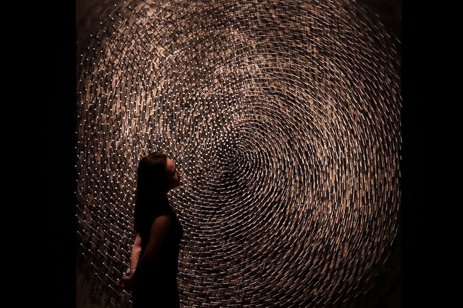 FILE - A Christie's auction house employee poses for photographs next to one part of German Sculptor's Guenther Uecker's "Spirale I, Spirale II (Doppelspirale)" at their premises in London, Friday, March 3, 2017. (AP Photo/Matt Dunham, File)