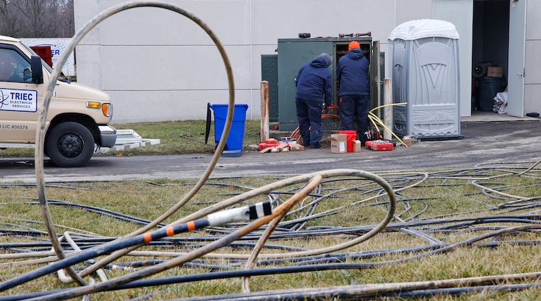 Two men work on the electrical box at the rear of Springfield High School Monday, Jan. 29, 2024. Springfield High School canceled class Monday due to an electrical problem. BILL LACKEY/STAFF
