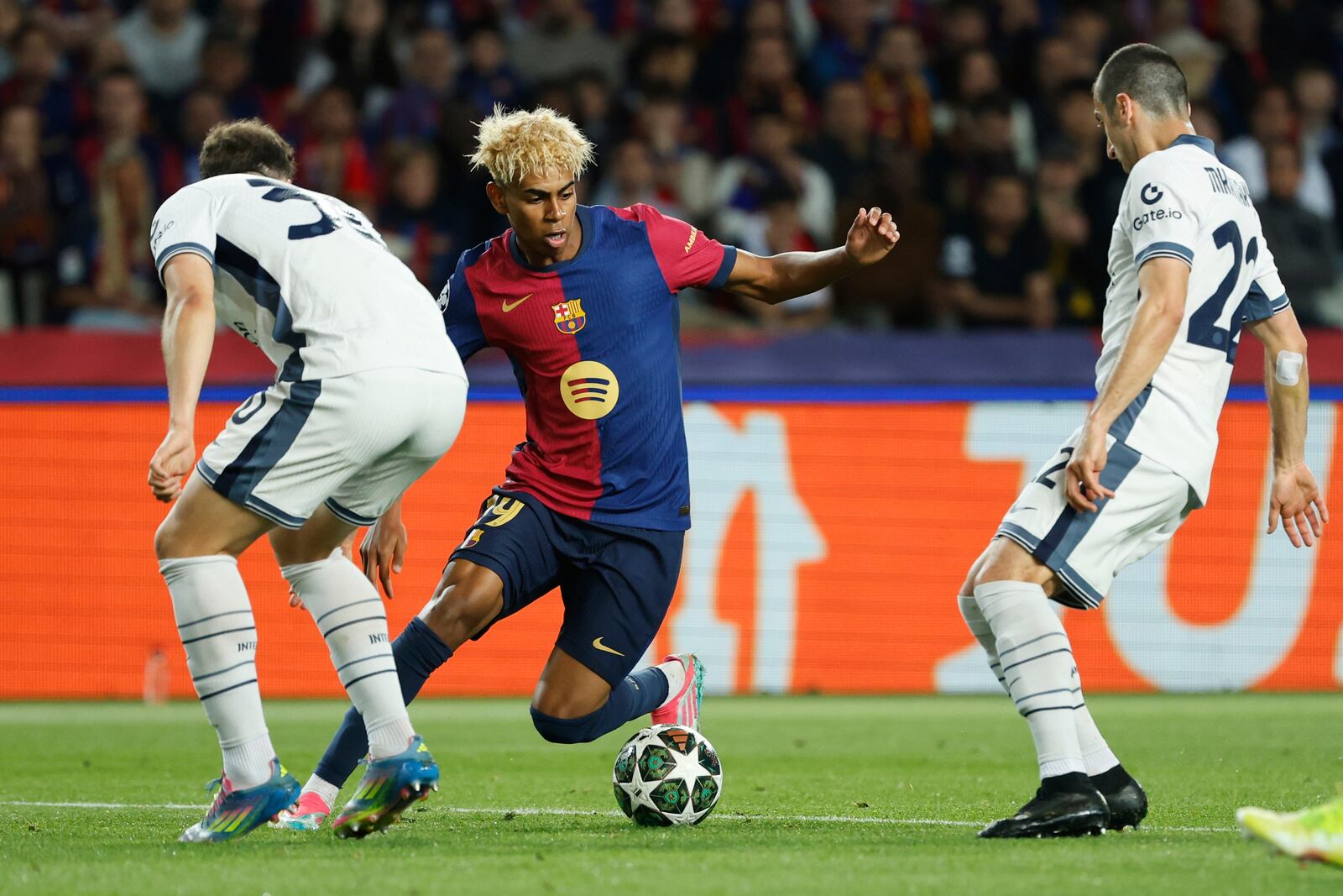 Barcelona's Lamine Yamal, center, is challenged by Inter Milan's Carlos Augusto, left, and Inter Milan's Henrikh Mkhitaryan during the Champions League semifinal first leg soccer match between Barcelona and Inter Milan at the Lluis Companys Olympic Stadium in Barcelona, Spain, Wednesday, April 30, 2025. (AP Photo/Joan Monfort)