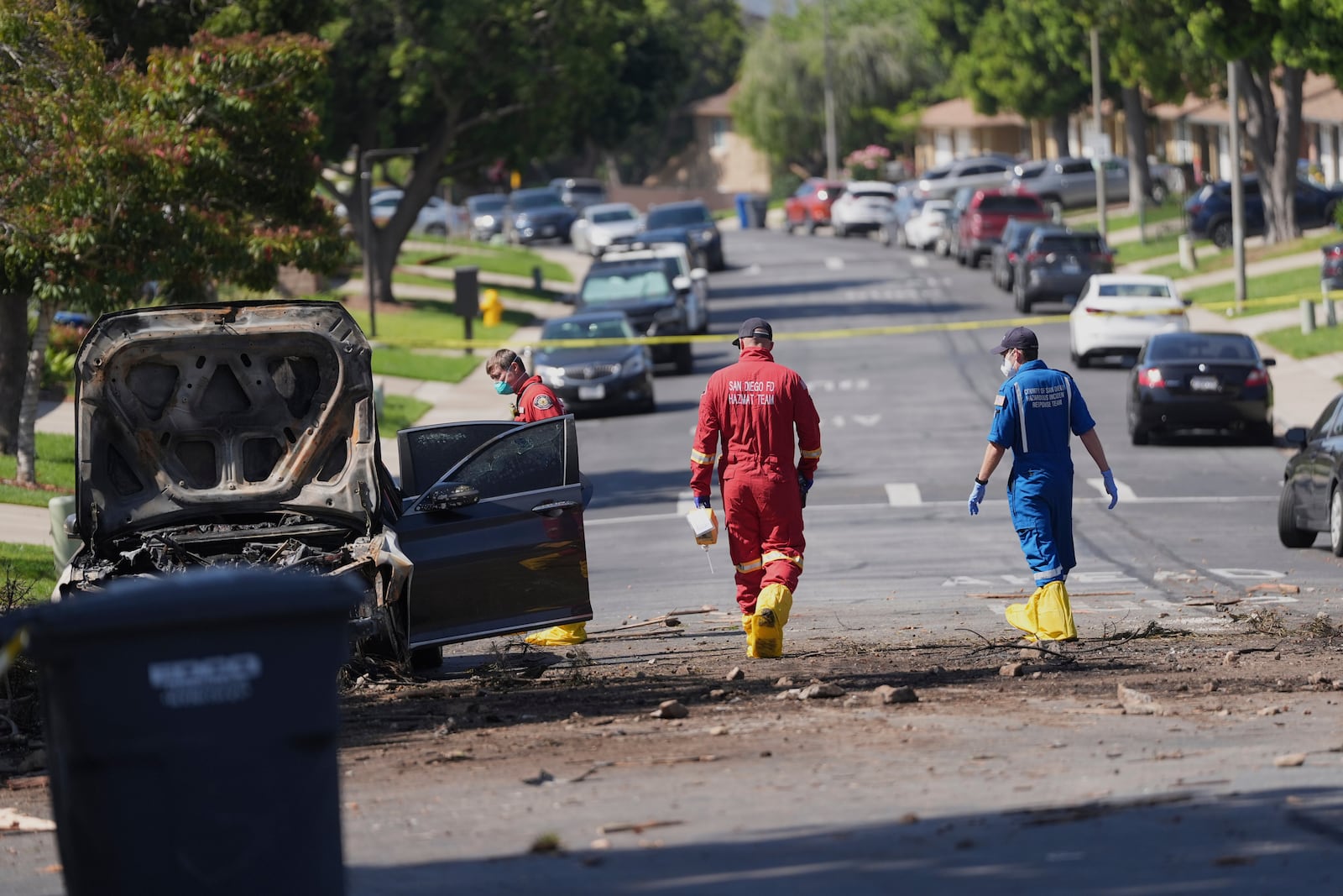 Authorities work the scene where a small plane crashed into a San Diego neighborhood, setting several homes on fire and forcing evacuations along several blocks early Thursday, May 22, 2025. (AP Photo/Gregory Bull)