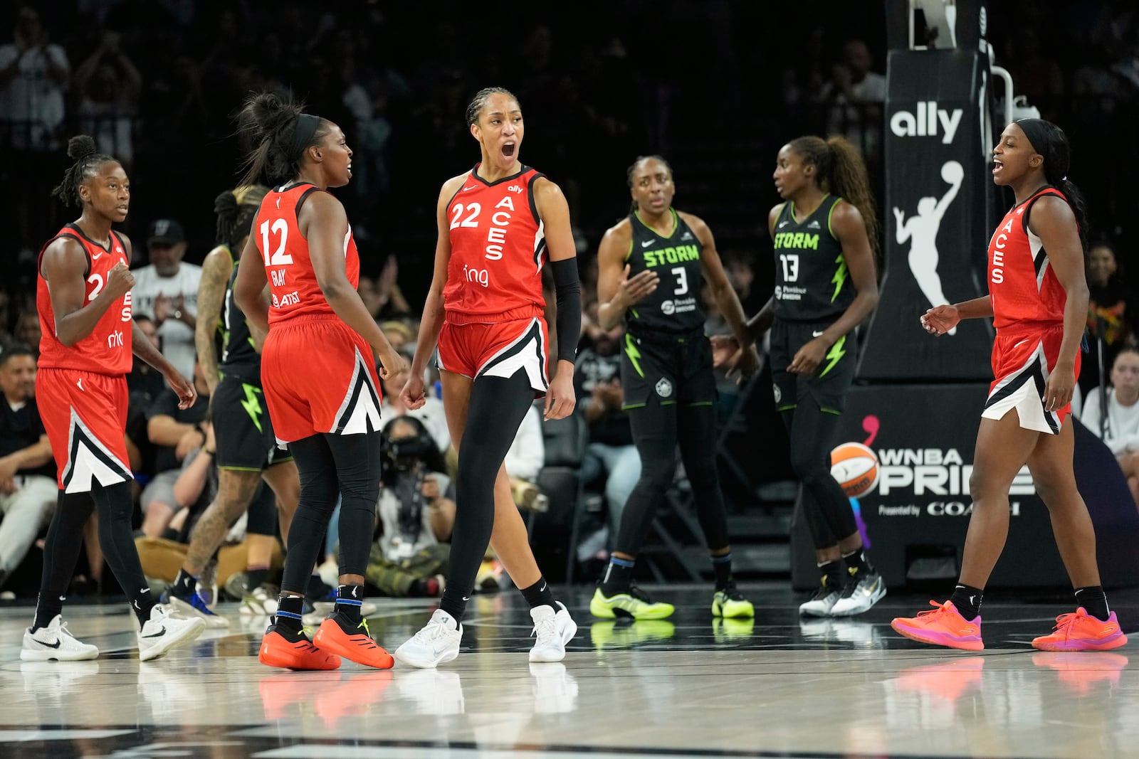 Las Vegas Aces guard Chelsea Gray (12) and center A'ja Wilson (22) celebrate after a play against the Seattle Storm during the first half of a WNBA basketball game Friday, June 20, 2025, in Las Vegas. (AP Photo/John Locher)