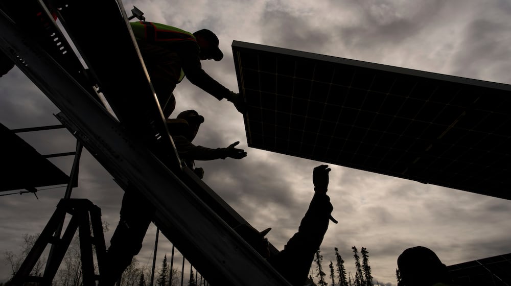 FILE - Workers install panels at a solar project May 21, 2025, in Galena, Alaska. (AP Photo/John Locher, File)