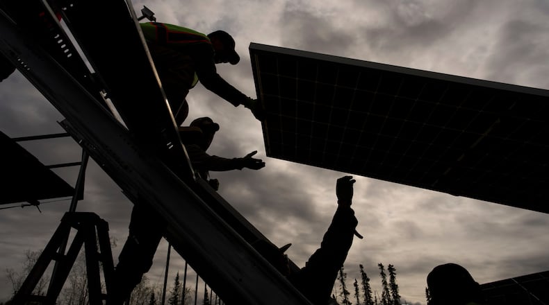 FILE - Workers install panels at a solar project May 21, 2025, in Galena, Alaska. (AP Photo/John Locher, File)