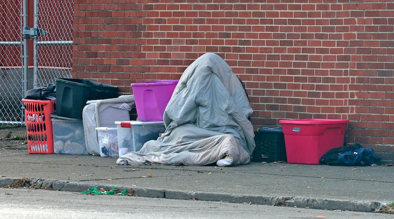 A homeless person tries to hide from the morning chill under a blanket Thursday, Nov. 7, 2024 along West Main Street in Springfield. BILL LACKEY/STAFF