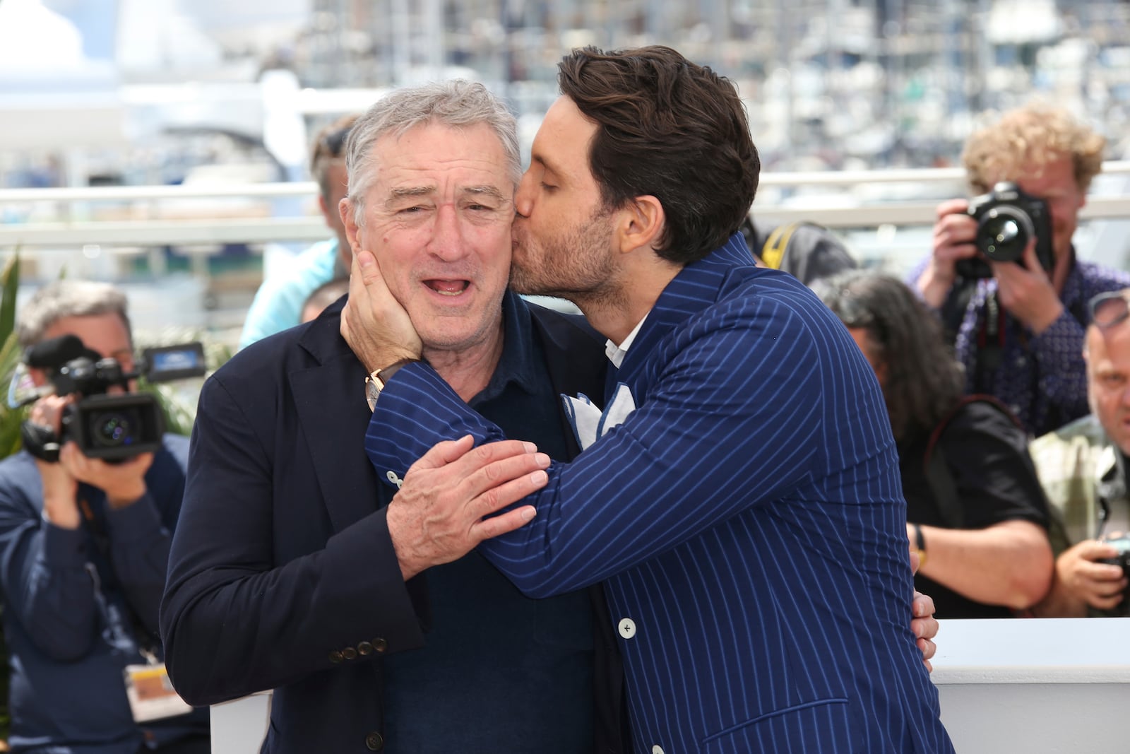 FILE - Actor Edgar Ramirez, right, kisses fellow actor Robert De Niro during a photo call for "Hands of Stone" at the 69th international film festival, Cannes, southern France on May 16, 2016. (AP Photo/Joel Ryan, File)