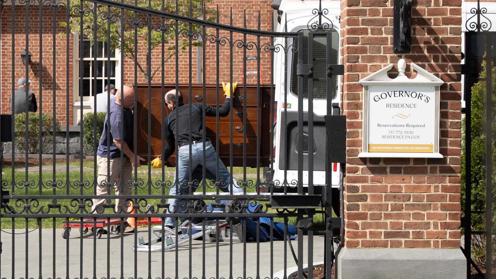 Workers move furniture following an arson attack on the Pennsylvania Governor's official residence in Harrisburg, Pa., Tuesday, April 15, 2025. (AP Photo/Mingson Lau)