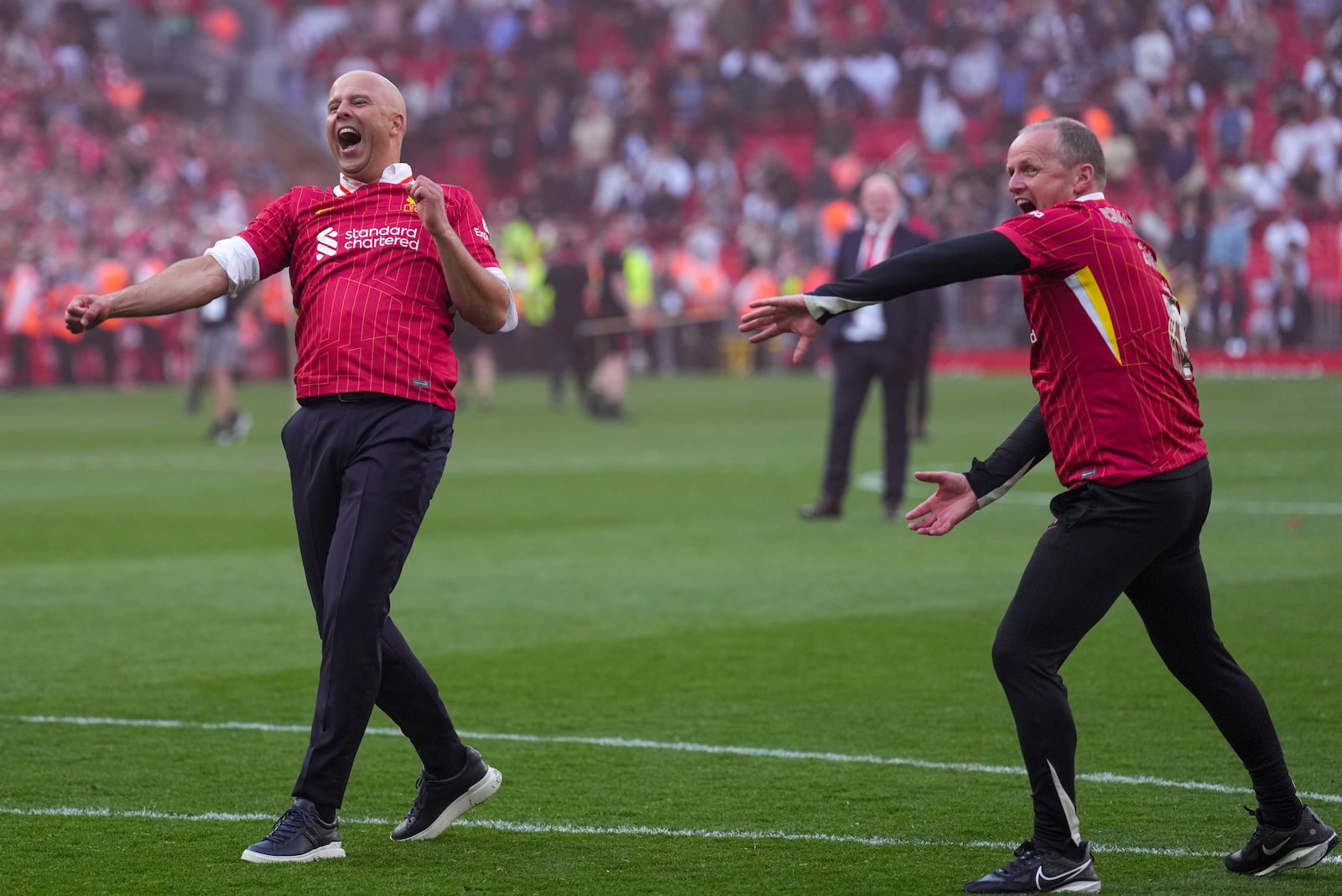 Liverpool's manager Arne Slot, left, celebrates after winning the English Premier League soccer match between Liverpool and Tottenham Hotspur and clinching the Premier League title at Anfield in Liverpool, England, Sunday, April 27, 2025. (AP Photo/Jon Super)