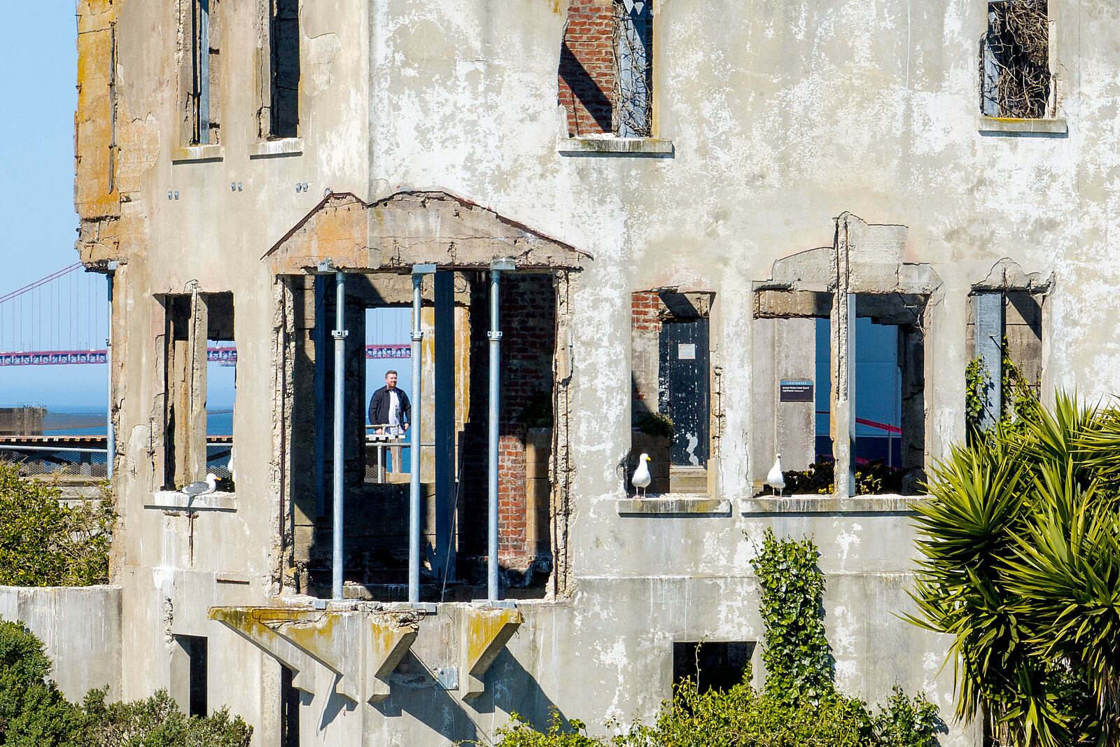 A visitor looks at the warden's house at Alcatraz Island on Monday, May 5, 2025, in the San Francisco Bay, Calif. (AP Photo/Noah Berger)