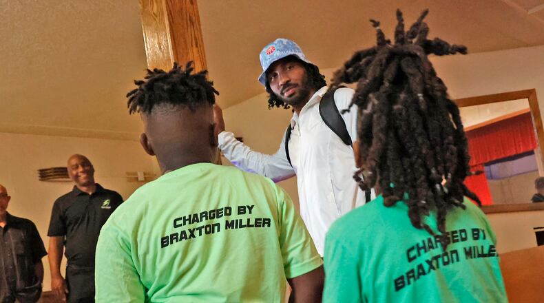 Students are greeted by Ohio State football standout Braxton Miller as they enter the Springfield Sports Academy Wednesday, August 23, 2023 for the first day of school. BILL LACKEY/STAFF