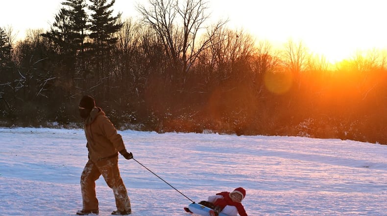 A man pulls his young daughter up the snow covered hill at Reid Park after sledding down at sunset. BILL LACKEY/STAFF