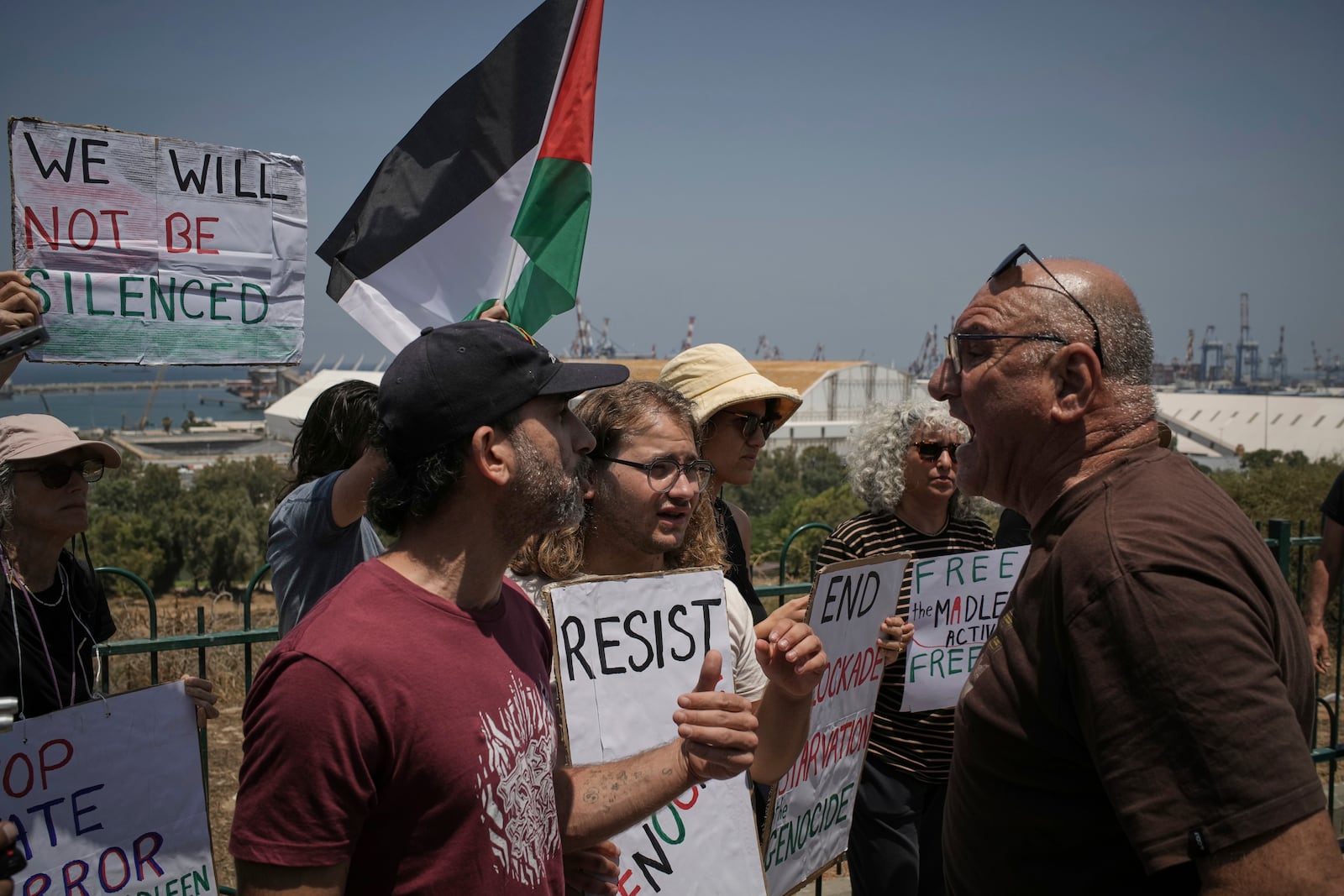 A man argues with people supporting Greta Thunberg and other activists who tried to deliver aid to Gaza before their ship was seized and they were detained by Israeli forces, near the port of Ashdod, Israel, Monday, June 9, 2025. (AP Photo/Leo Correa)