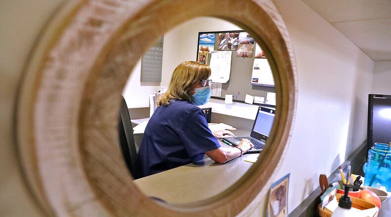 Beth Neville enters patient information into a computer Tuesday at The Rocking Horse Center. BILL LACKEY/STAFF