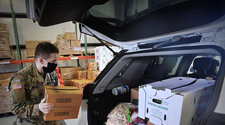 A member of the National Guard loads fresh food into the back of a vehicle at The Foodbank Thursday. MARSHALL GORBYSTAFF