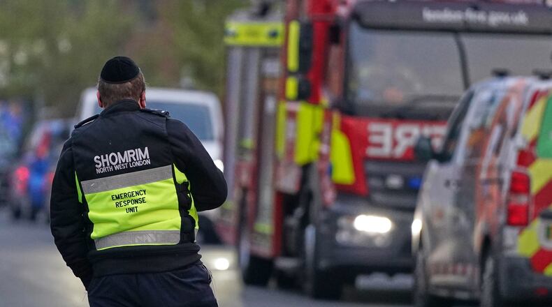 An officer from an emergency response unit watches a firefighter response team in London, Monday, March 23, 2026 after an apparent arson attack on four vehicles belonging to the Jewish ambulance service, Hatzola Northwest, in London.(AP Photo/Alberto Pezzali)